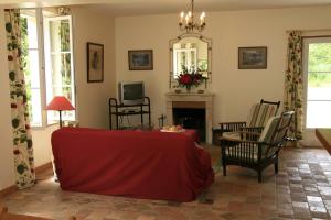 uma sala de estar com um sofá vermelho e uma lareira em Gîte du Moulin de Montrésor em Montrésor