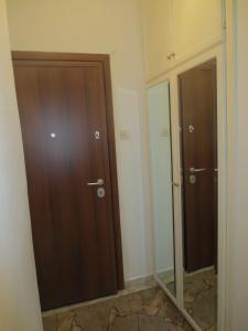 a bathroom with two wooden doors and a mirror at Studio Anna Veria Center in Veria
