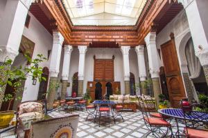 una habitación con mesas y sillas en un edificio en Riad Dar Skalli & SPA, en Fez