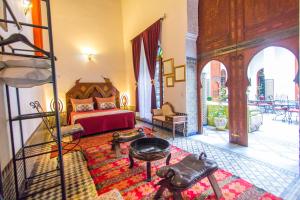 a bedroom with a bed and a table in a room at Riad Dar Skalli & SPA in Fès