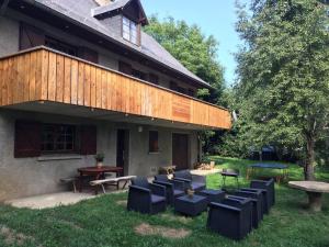 un patio con sedie e tavoli di fronte a una casa di Le Chant de l'eau a Garin