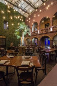 restauracja ze stołami i krzesłami oraz zieloną ścianą w obiekcie Alqueria de Carrion Hotel Boutique w mieście Atlixco