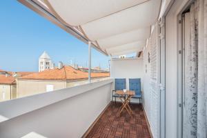 an empty balcony with a table and chairs on it at City Vibe Studios in Zadar
