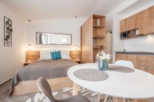 a bedroom with a bed and a table and chairs at City Vibe Studios in Zadar