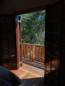eine offene Tür zu einer Terrasse mit einem Baum in der Unterkunft Chalé da Bel in Santo Antônio do Pinhal