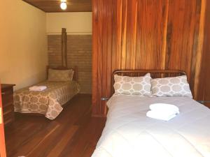 - une chambre avec un lit et une chaise dans l'établissement Chalé da Bel, à Santo Antônio do Pinhal