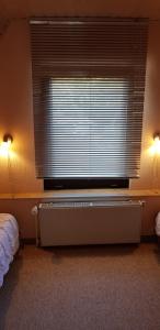 a bedroom with a large window with a radiator under it at Haus am Koiteich in Plau am See