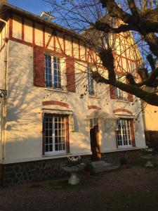 ein weißes Haus mit zwei Fenstern und einem Baum in der Unterkunft Logis du Petit Dodo in Sainte-Jamme-sur-Sarthe