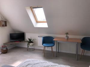 une chambre avec une table, deux chaises et une télévision dans l'établissement Chambre d'hôtes La Bourdonnaise, à Bourdonné
