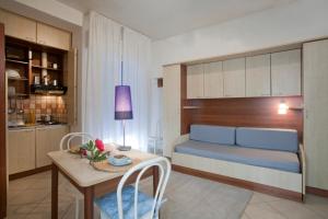 a living room with a bed and a table in a room at Residence Mediterraneo in Rimini