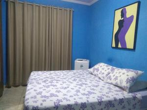 a bedroom with blue walls and a bed with a pillow at Hospedagem Vovó Gina in Aracaju