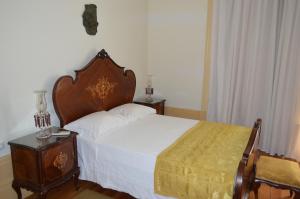 a bedroom with a large bed with a wooden headboard at Casa Vermelha in Vila Nova de Foz Coa