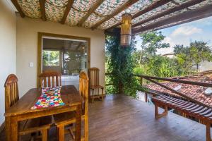 a porch with a wooden table and chairs on a deck at Pousada Brisa Da Barra in Barra Grande