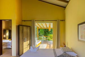 a bedroom with a bed and a sliding glass door at Pousada Brisa Da Barra in Barra Grande