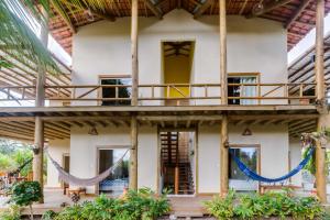 a house with a hammock in front of it at Pousada Brisa Da Barra in Barra Grande