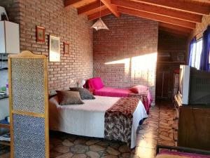 Un dormitorio con una cama en una pared de ladrillos. en Monoambiente Amplio, en La Falda