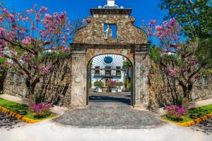 クエルナバカにあるAnticavilla Hotel Restaurante & Spaのピンクの花の石造りの建物の入口