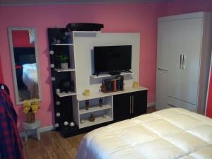 a bedroom with a bed and a tv on a shelf at Playa, bosque y lago in Montevideo +74 photos