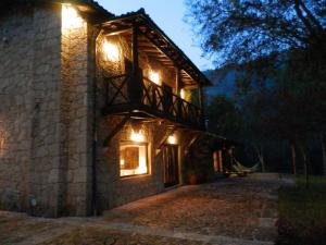 a stone house with lights on the side of it at Quinta do Caneiro in Geres