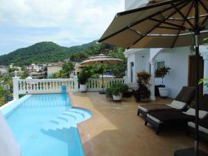 uma piscina com cadeiras e um guarda-sol numa varanda em Taboga Palace SPA Hotel em Taboga