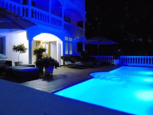 una piscina iluminada de azul por la noche en Taboga Palace SPA Hotel, en Taboga