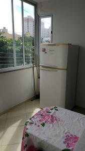 a kitchen with a refrigerator in a room with windows at Hospedagem Praia de Itaparica in Vila Velha