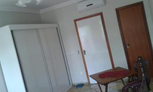 um quarto com dois armários brancos e uma cadeira em Hospedagem Praia de Itaparica em Vila Velha