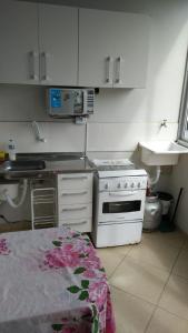 uma pequena cozinha com um fogão e um lavatório em Hospedagem Praia de Itaparica em Vila Velha