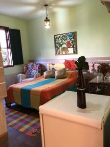 1 dormitorio con 2 camas, sofá y mesa en Pouso Realeza, en Tiradentes