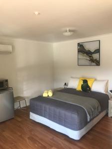 a bedroom with a bed with a cat sitting on it at Terraced Chalets in Motueka +11 photos