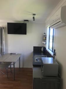 - une cuisine avec un évier et une table dans une chambre dans l'établissement Terraced Chalets, à Motueka
