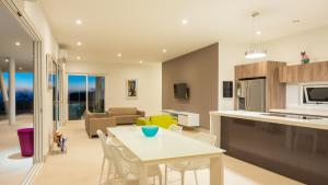 VillaCasaBella Ocean View-Private Pool-Up to 12 Guests في Willibrordus: مطبخ وغرفة معيشة مع طاولة وكراسي