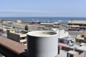 una tazza di caffè seduta in cima a un balcone di Torreblanca Hotel a Ilo