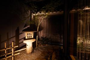 a bird house sitting next to a fence at night at Rinn Gion Kenninji in Kyoto