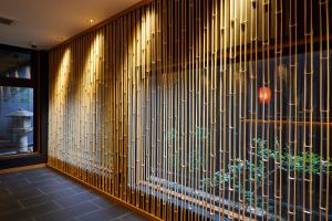 a room with a wall covered in wooden vertical lines at Rinn Gion Kenninji in Kyoto