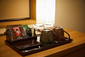 a tray with two mugs and books on a table at Rinn Gion Kenninji in Kyoto
