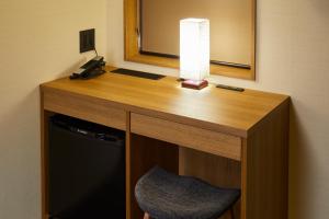 a desk in a hotel room with a lamp and a chair at Rinn Gion Kenninji in Kyoto