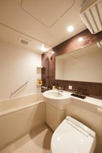 a bathroom with a toilet and a sink and a mirror at Rinn Gion Kenninji in Kyoto