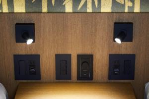a wall with four pay phones and lights on it at Rinn Gion Kenninji in Kyoto