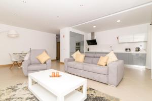 a living room with a couch and a table at Beach Condominium in Lagos +6 photos