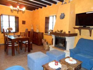 a living room with blue chairs and a fireplace at Casa El Campu in Infiesto