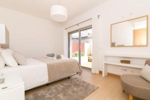 a white bedroom with a bed and a mirror at Beach Condominium in Lagos