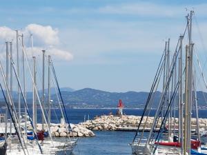 een groep boten aangemeerd in een haven met een vuurtoren bij Le LUMIERE in La Ciotat