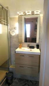 een badkamer met wastafel en douche met spiegel bij Le LUMIERE in La Ciotat