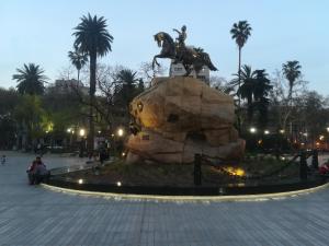 a statue in a park with palm trees at night at Monoambiente en Mendoza in Mendoza