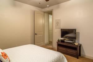 een slaapkamer met een bed en een flatscreen-tv bij Hurricane Hill Home in Hurricane