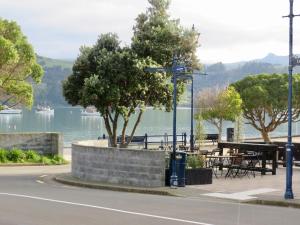 a view of a lake with a table and trees at The Studio Akaroa in Akaroa