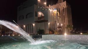 a fountain in front of a building at night at 夏日澄藍The Charming Land in Baisha