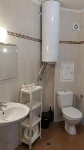 a white bathroom with a sink and a toilet at GENIKO Apartments in Pomorie +33 photos