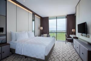 Postel nebo postele na pokoji v ubytování Wyndham Opi Hotel Palembang